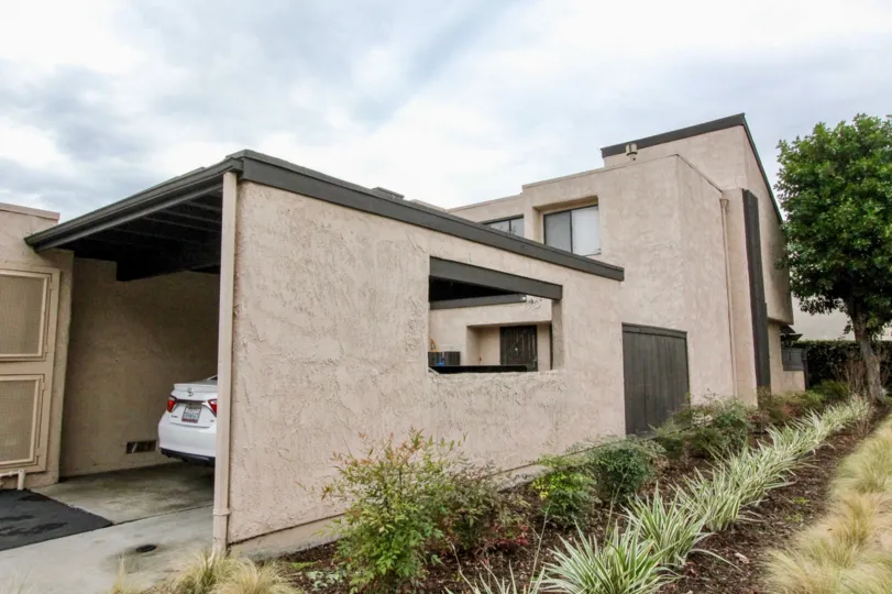THIS IMAGE SHOWS THE HOUSE WITH CAR SHED, ON THE SIDE PLANTS, GRASSES, TREES ARE THERE IN ANAHEIM CITY