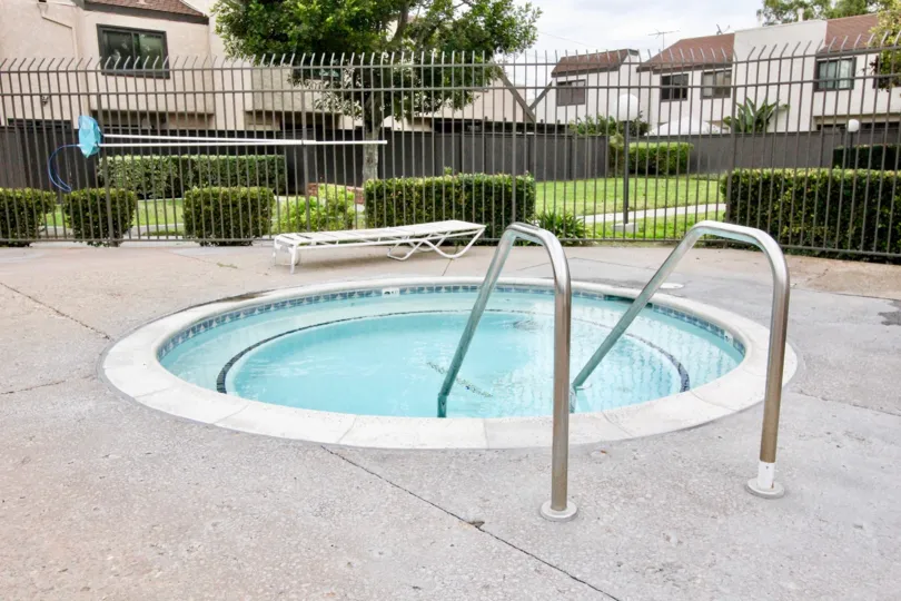 Fabulous round shaped swimming pool with lawn near villas in Heritage Village Townhomes of Anaheim