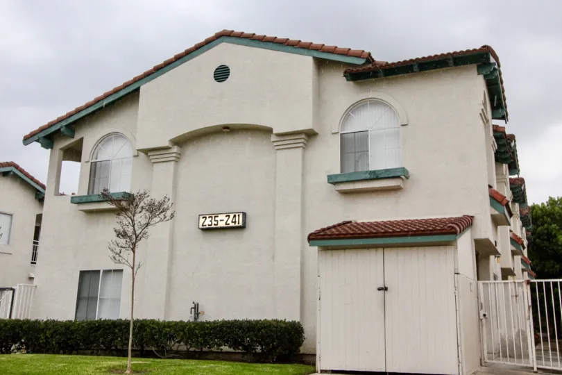 THE FLATS WITH LAWN, SMALL PLANTS, TREES ON THE FRONT, NUMBER BOARD ON THE WALL IN ANAHEIM CITY