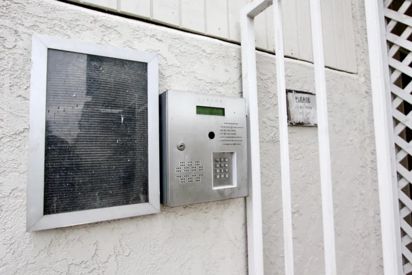 Near the gate of Villa in La Vie En Rose has security phone with some attention paper near to it