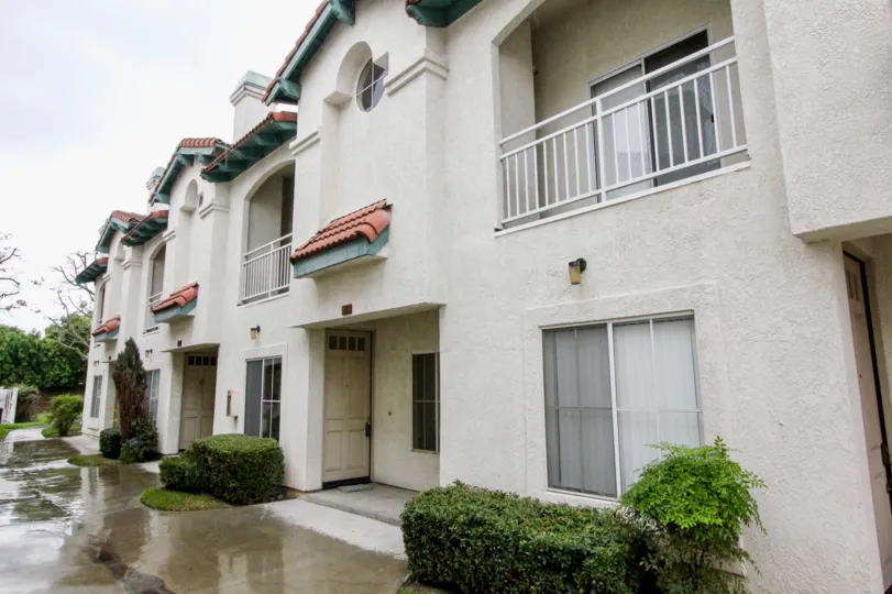 A white apartment building with balconies on a rainy day