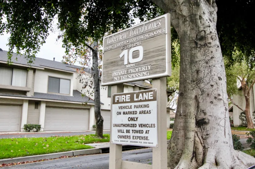 The home in lakeview townhomes with big trees, lawn and nameboard