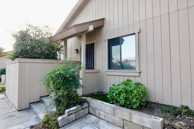 A covered front entrance of a residence in the Laurelwood Village community with vertical claddin.