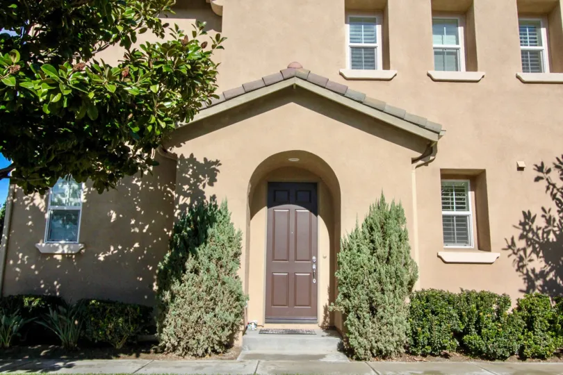 THE FRONT OF THE HOME WITH PLANTS, TREES ARE SHOWN IN ANAHEIM CITY