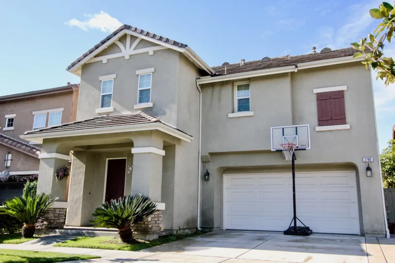 a pleasant day in the magnolia lane with a house that has parking door closed and garden in front