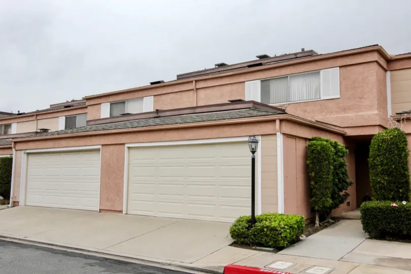 Rose colored condos with two street-facing garages found in the Northwoods Village of Anaheim, California