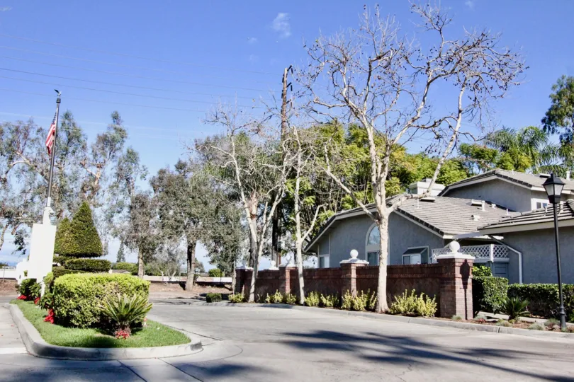 THIS IMAGE SHOWS THE ROADWAY WITH PLANTS AND TREES, FLAG ARE THERE IN ANAHEIM CITY