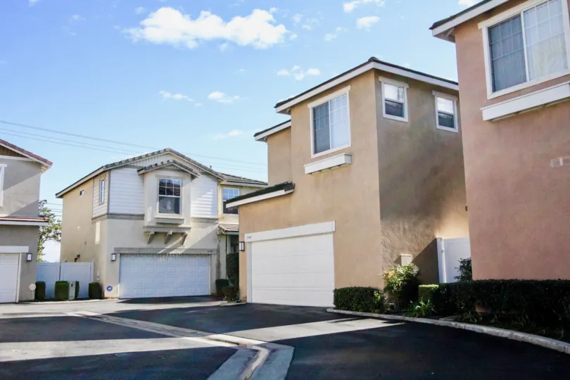 THIS IMAGE SHOWS FEW HOMES WITH SHEDS IN ANAHEIM THAT HAVE THE ROAD WAY, SMALL PLANTS ARE THERE