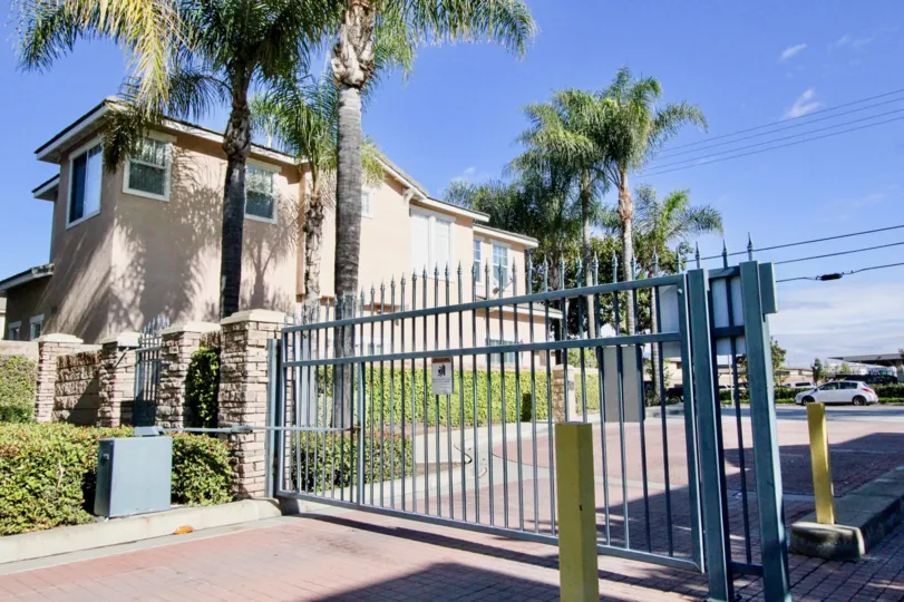 A sunny day in Peppertree Walk with security gate and two story house