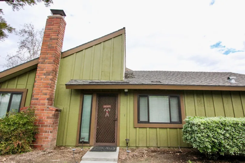 A SUNNYDE, A BEAUTIFUL LIGHT GREEN COLOR HOUSE IN THE WTH SOME SHURBS