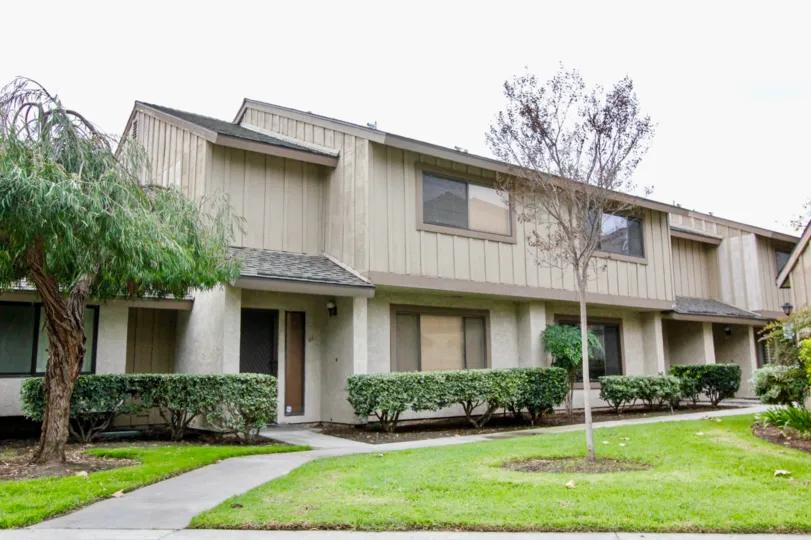 THIS IMAGE SHOWS THE HOUSE IN ANAHEIM CITY, THAT SHOWS THE BEAUTIFUL LAWN, CROTON PLANTS, TREES ARE THERE