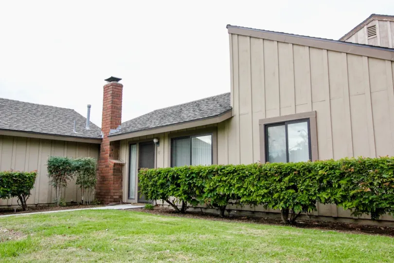 A lawn in Pepperwood Village with some plants and building.