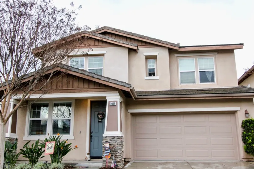 A large brown garage door inside of a home with a tree at Rio vista Walk in Anaheim CA