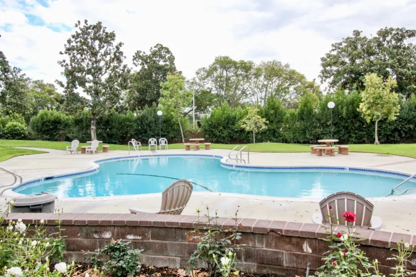 Swimming pool with blue water lies calm amid spectacular greenery in Sherwood Village community