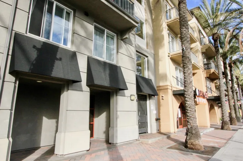 A sunny day with palm trees on the outside of the apartment complex of Stadium Lofts in Anaheim, California.