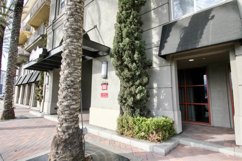 THIS IMAGE SHOWS THE ENTRANCE WAY THAT HAVE LONG TREES AND NUMBER BOARD ON THE WALL IN ANAHEIM CITY