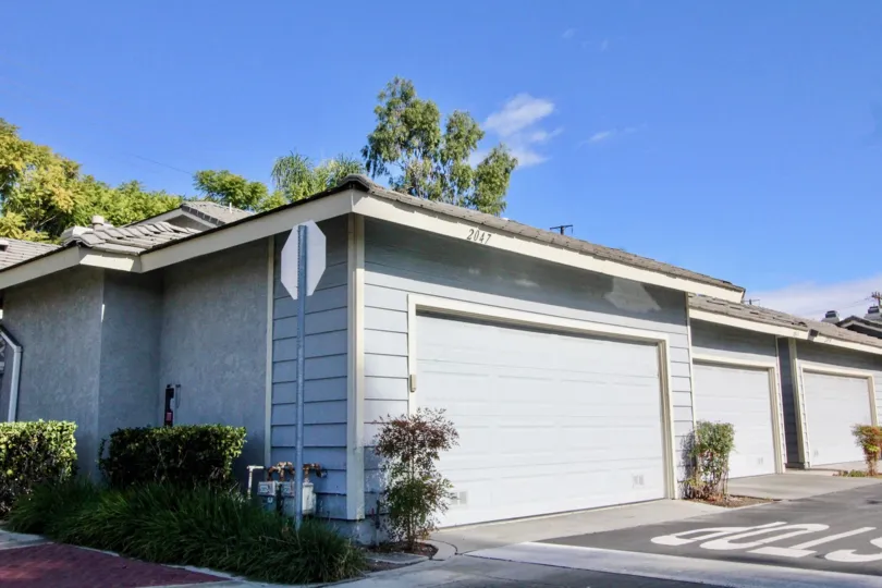 A WARM DAY IN THE STANFORD Court WITH A BUILDING THAT HAS PARKING DOOR CLOSED AND SIDE OF TREES AND NUMBERED 2047 AND AROUND THE GARDEN