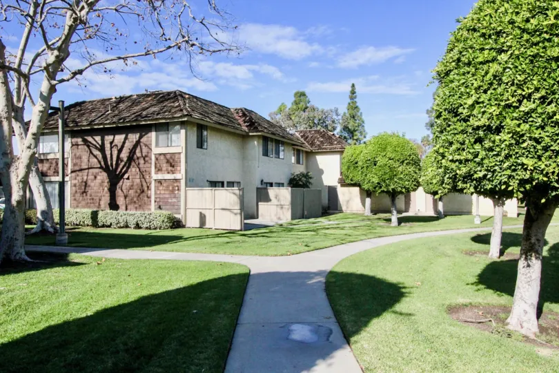 A beautiful garden in the Sutter Creek Townhomes with a building.