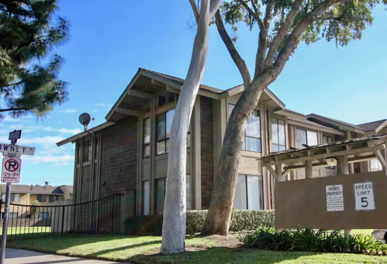 A WARM DAY IN THE Sutter Creek Townhomes WITH A HOUSE THAT HAS TWO TREES IN FRONT AND ROOF LESS TOP