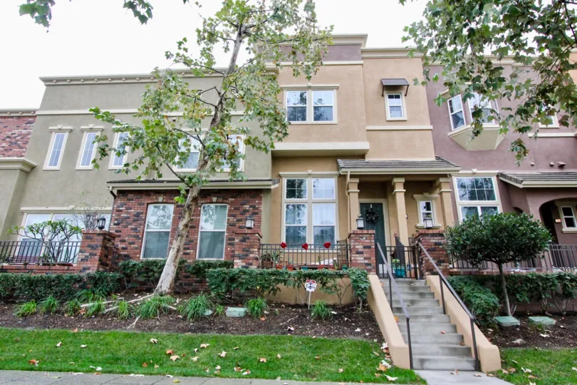 a pleasant day in the domain with a house that has steps in center and stone walls and garden around