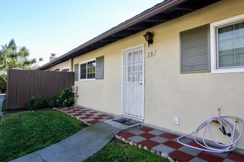 THIS IMAGE SHOWS THE OUTSIDE OF THE HOME THAT HAVE NUMBER ON THE WALL, LAWN, PLANTS ARE THERE IN ANAHEIM CITY