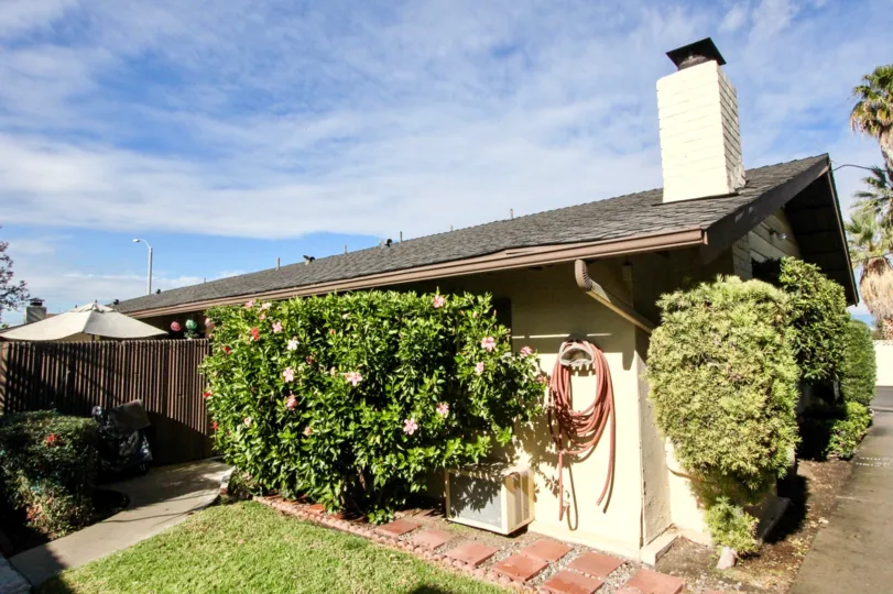 A sunny day in the pines with guest house, lawn, plants, pipes and street road