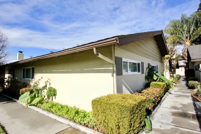 THIS IMAGE VIEWS THE SMALL VILLA SURROUNDED BY PLANTS ON THE PATHWAY IN THE PINES COMMUNITY