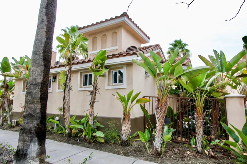 THE SIDE VIEW OF THE HOUSE WITH SMALL TREES ON THE PATHWAY LOCATED IN ANAHEIM CITY