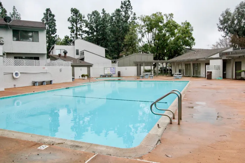A sunny day in villa frontera with homes and swming pools, lots of trees. Look like a resort.