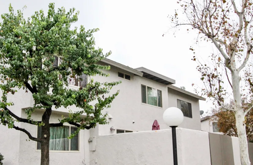 A cloudy day in the Villa Frontera with a ash color building and trees.
