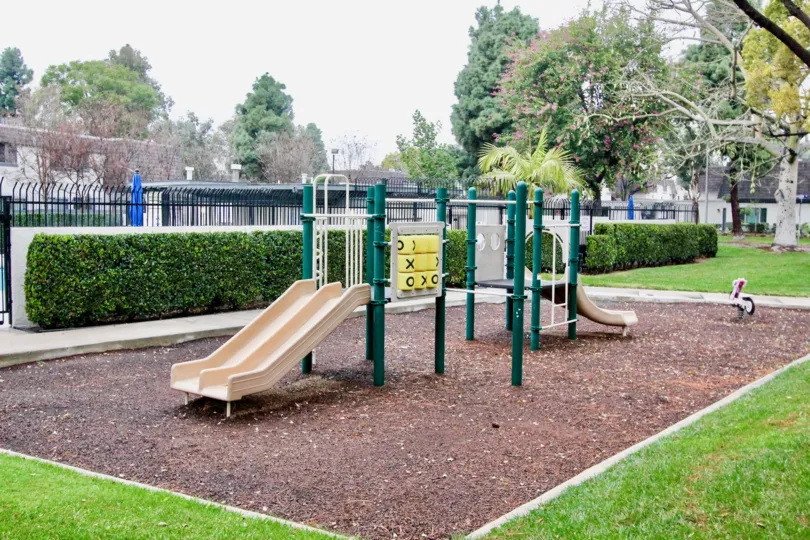 a rainy day in the village green with a park that has children will plays in circus and garden around