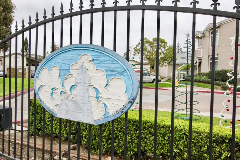 A beautiful entrance gate in wellington landing inside full of green plants and buildings
