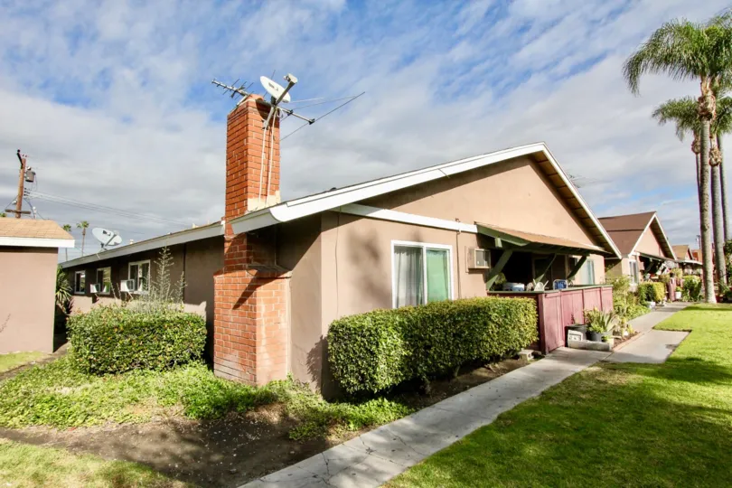 THIS IMAGE SHOWS THE HOUSE WHICH IS IN ANAHEIM, THAT HAVE DISH, ANTENNA ON THE TOP, FRONT LAWN, SMALL PLANTS, TREES THERE