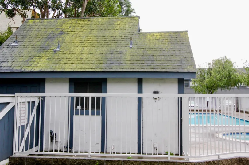 A white painted gated house in the Wind River neighborhood with its own glistering blue swimming pool