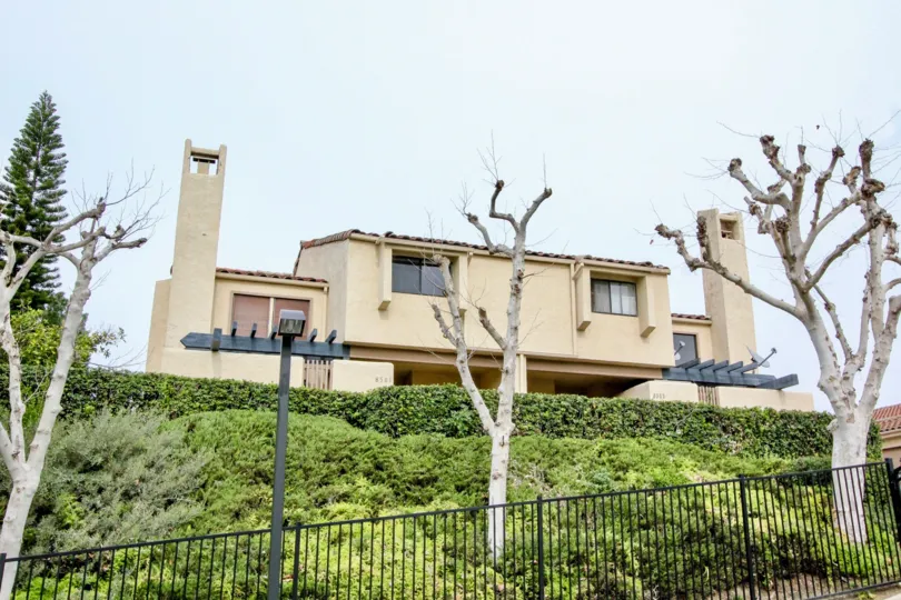 THIS IMAGE VIEWS THE SIDE VIEW OF HOUSE WITH LOT OF PLANTS SURROUNDED BY THE GATE WHICH IS LOCATED IN BUENA PARK