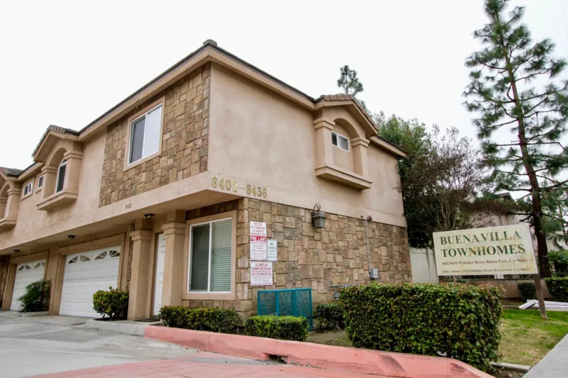 a warm day in the buena villa town homes with a building that has numbered as 840 8436 and 2 parking door closed