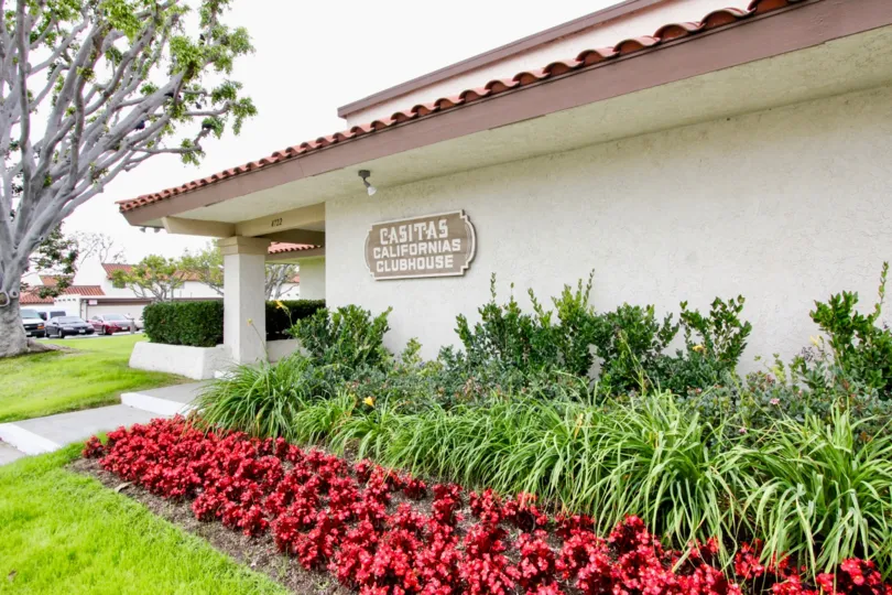 a pleasant day in the casitas california with a building that has garden around and trees in front