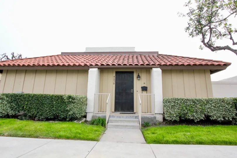 THE SMALL HOUSE IN BUENA PARK, WHICH SHOWS LAWN, CROTON PLANTS ON BOTHSIDE, NUMBER ON THE WALL IS THERE