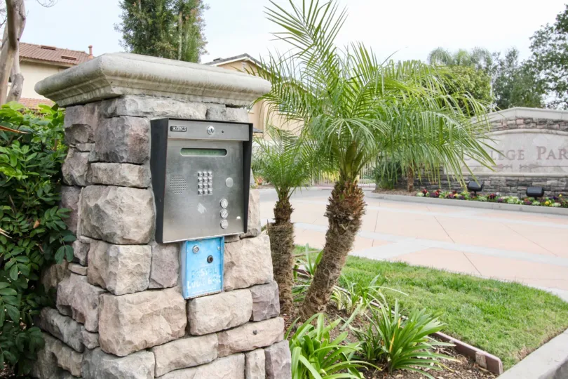 THIS IS THE ENTRANCE WAY WITH CALLER MACHINE ON THE SIDE PLANTS TREES ARE THERE IN BUENA PARK