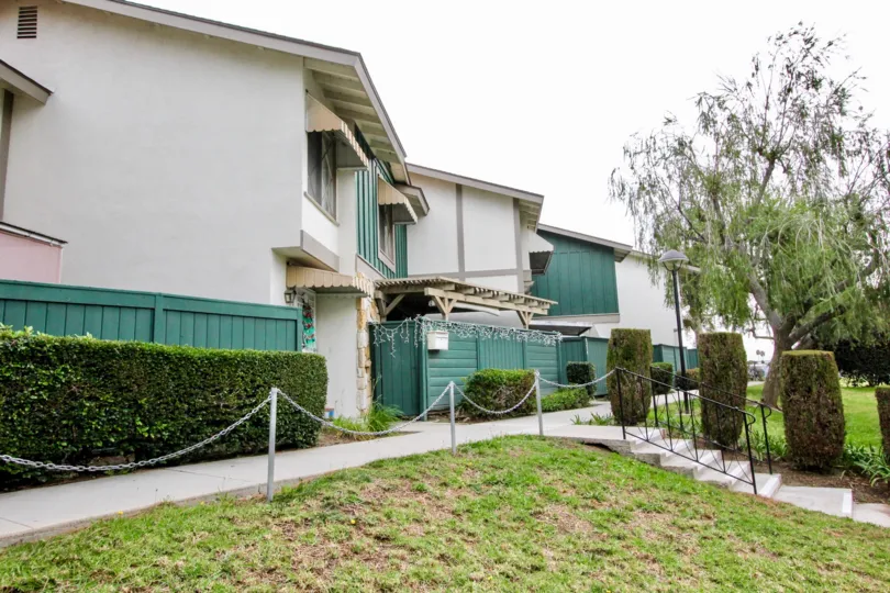 THE SIDEVIEW OF THE VILLAS WITH BEAUTIFUL GARDEN WITH PLANTS, TREES LOCATED IN HIGHLAND GREENS