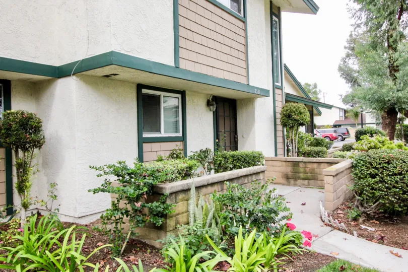 Nice view of villa with flower garden and trees in Highland Greens of Buena Park