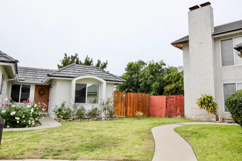 THE VILLA IN BUENA PARK, WHICH SHOWS THE BEAUTIFUL LAWN WITH PLANTS WITH FLOWERS, CROTON PLANTS