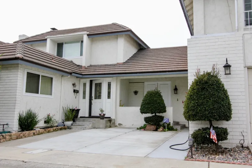 A home and driveway with scultped trees on a cloudy day in Meadowbrook