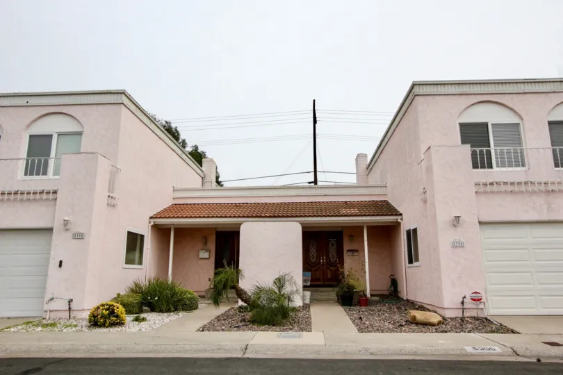 A house in Meadowbrook with small plants, bushes and flower pots in front of the house