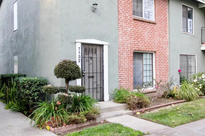 THE 7132 APARTMENT IN THE MONTICELLO TOWNHOMES WITH THE FLOWER PLANTS, LAWN, TREES