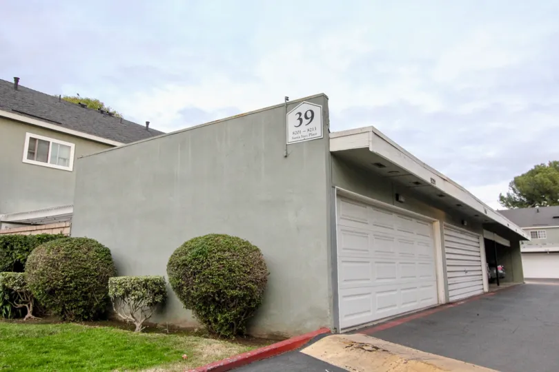 At the wall of Car shed in Monticello townhomes has bushes with meadows