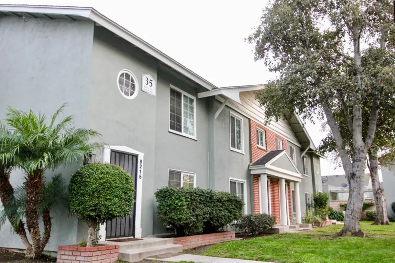 THE VILLA WITH NUMBER ON THE WALL IS IN BUENA PARK, ON THE FRONT LAWN, PLANTS, TREES ARE THERE