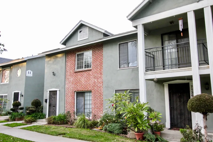 Villa in Monticello Townhomes has numbered as 7136 with flower pots and plants