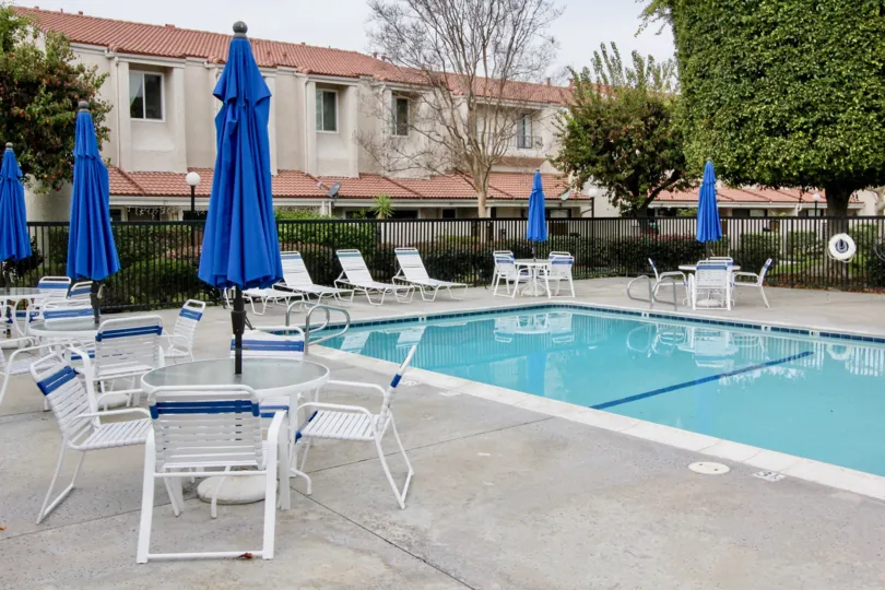 Fantastic view of Swimming pool with blue coloured umbrellas and chairs in Regency East of Buena Park
