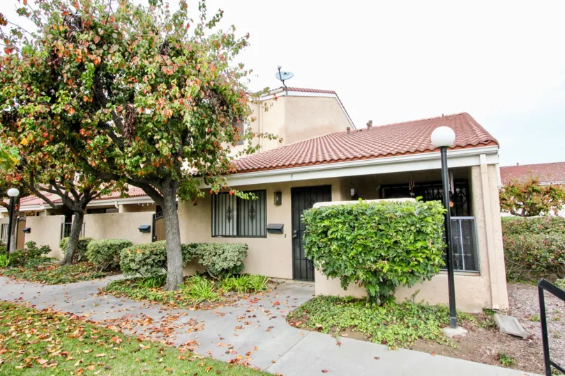 THIS IMAGE SHOWS THE HOUSE WITH PATHWAY, MANY PLANTS, TREES, ARE THERE IN BUENA PARK